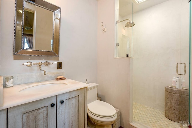bathroom with toilet, a walk in shower, and vanity