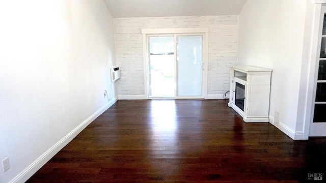 224 Walnut St, Suisun City, CA 94585 - unfurnished living room featuring brick wall, dark wood-style flooring, baseboards, and a glass covered fireplace
