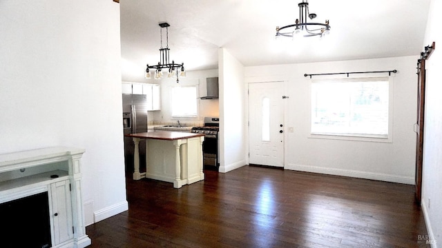 224 Walnut St, Suisun City, CA 94585 - kitchen with a notable chandelier, hanging light fixtures, wall chimney range hood, appliances with stainless steel finishes, and dark wood-style floors