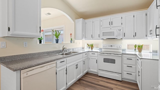 kitchen with visible vents, white appliances, dark wood-type flooring, white cabinetry, and a sink