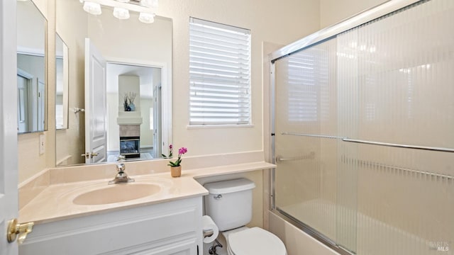 full bath featuring combined bath / shower with glass door, toilet, and vanity