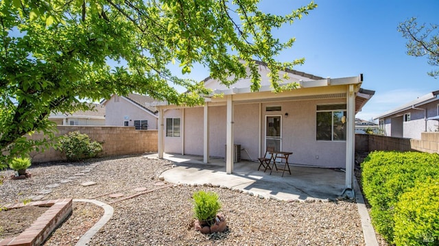 back of house with stucco siding, fence, and a patio area
