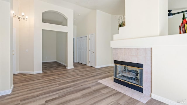 living room featuring baseboards, high vaulted ceiling, and wood finished floors