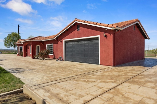 19810 S Spruce Rd, Los Banos, CA 93635 - view of front facade with a garage, driveway, a tiled roof, and stucco siding