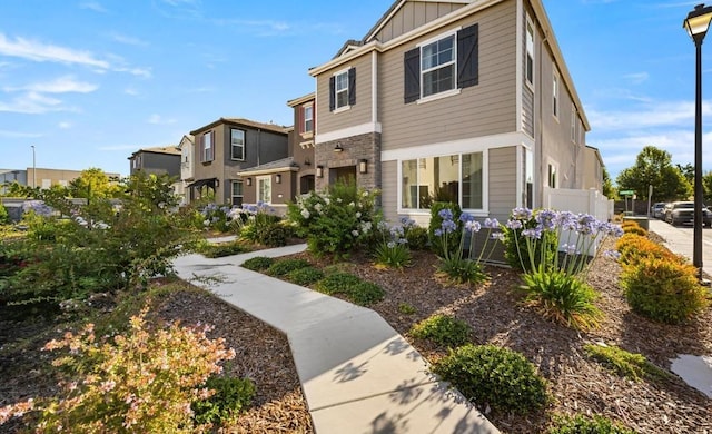 view of front of home featuring fence, board and batten siding, and a residential view