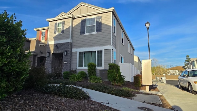 view of front of property featuring board and batten siding and fence