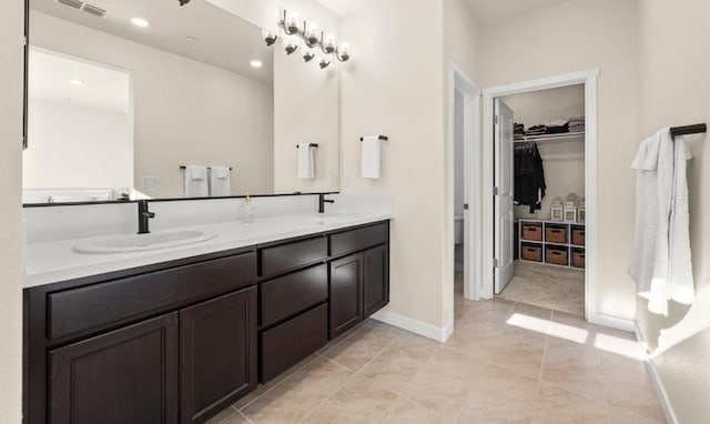 bathroom with double vanity, a sink, and tile patterned flooring