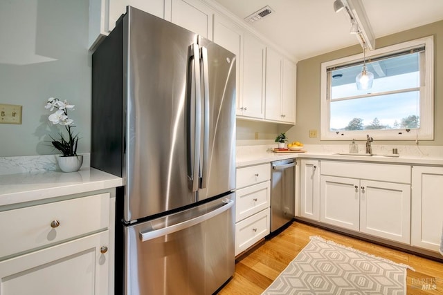 kitchen featuring visible vents, white cabinets, a sink, and appliances with stainless steel finishes