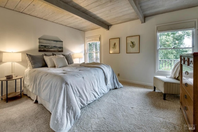 carpeted bedroom with wooden ceiling, baseboards, and beamed ceiling