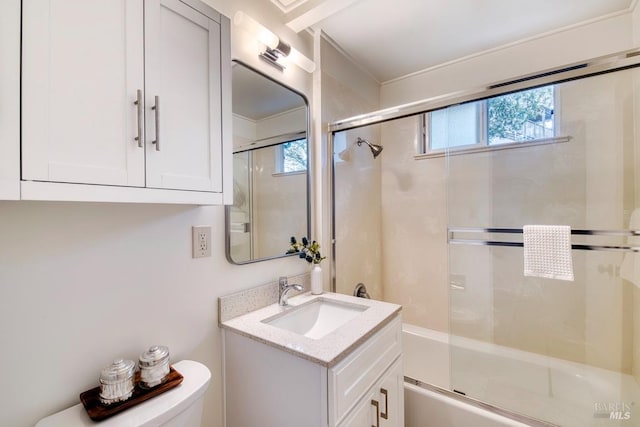 bathroom with toilet, vanity, and bath / shower combo with glass door