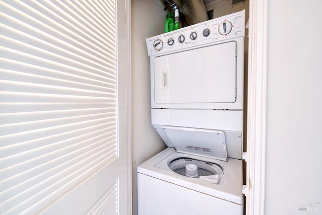 laundry room with stacked washer / drying machine and laundry area