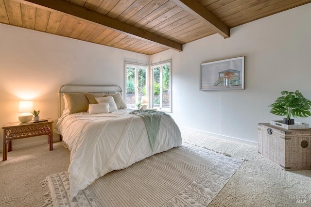 bedroom featuring baseboards, beamed ceiling, wood ceiling, and carpet