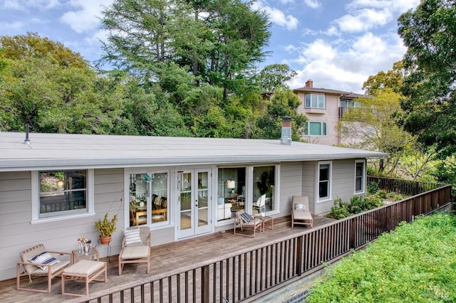 back of property featuring fence, a wooden deck, and french doors