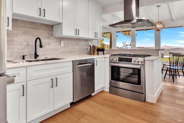 421 Rose Ave, Mill Valley, CA 94941 - kitchen featuring stainless steel appliances, island exhaust hood, a sink, light wood finished floors, and light countertops