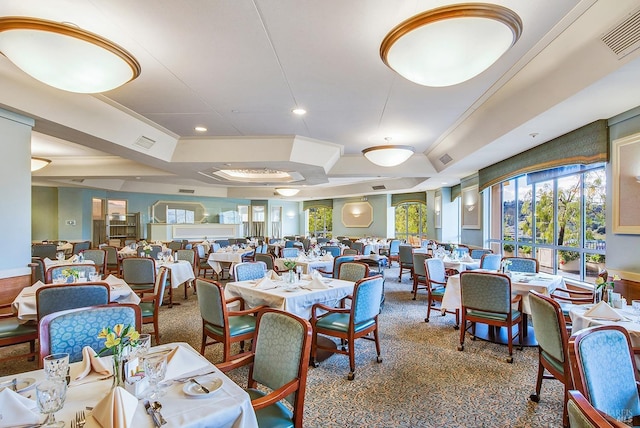 carpeted dining area with visible vents, a raised ceiling, and recessed lighting