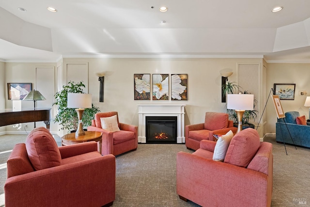 living area featuring a glass covered fireplace, recessed lighting, carpet flooring, and a tray ceiling