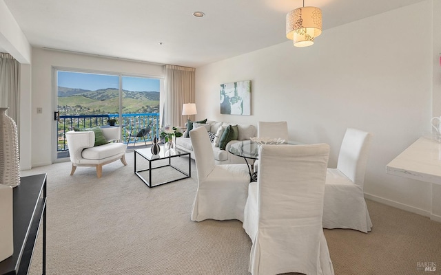 dining space with baseboards, light carpet, and a mountain view
