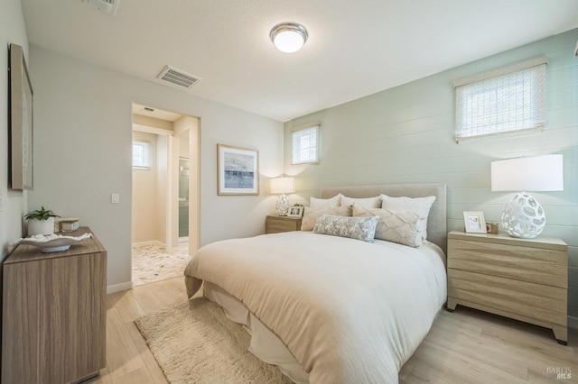 bedroom with baseboards, visible vents, and light wood-type flooring