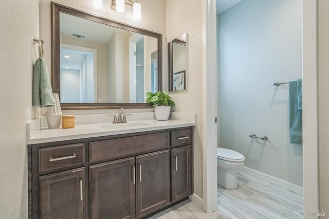 bathroom featuring toilet, baseboards, visible vents, and vanity