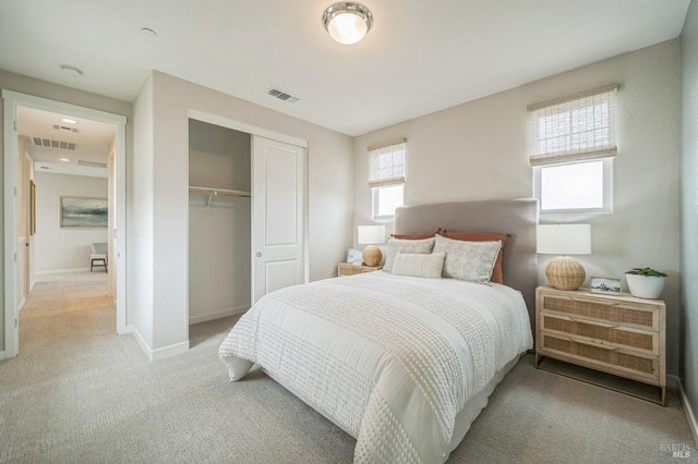 bedroom with a closet, baseboards, light colored carpet, and visible vents