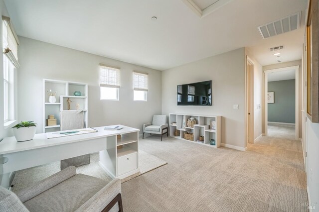 office space featuring visible vents, baseboards, and light colored carpet
