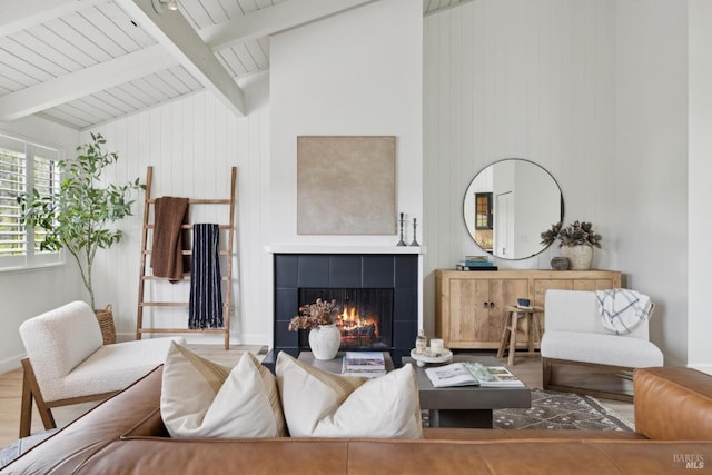 living room featuring wood finished floors, wooden ceiling, beamed ceiling, a fireplace, and high vaulted ceiling