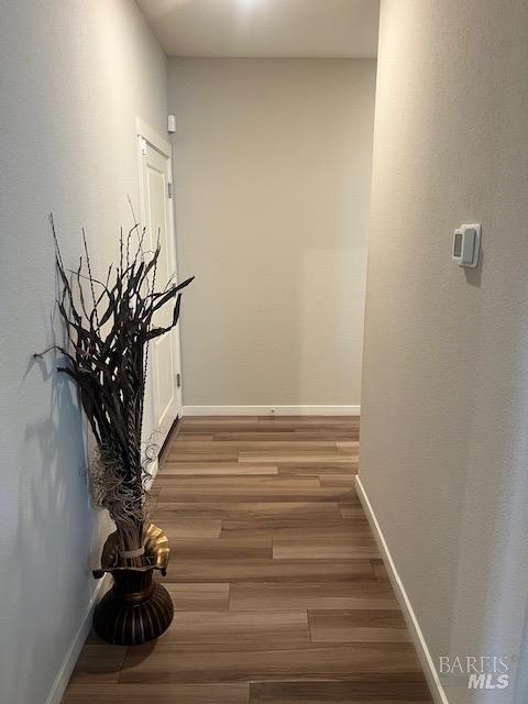 corridor featuring baseboards and light wood-style floors