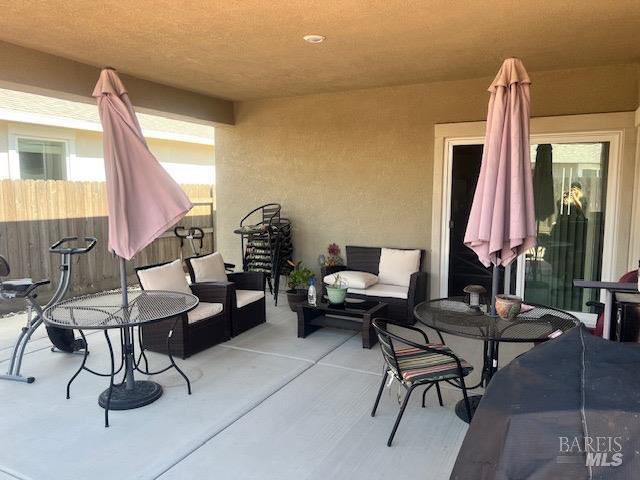 view of patio featuring an outdoor living space and fence