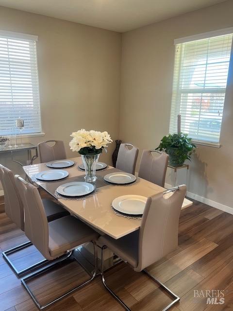 dining space featuring baseboards and wood finished floors