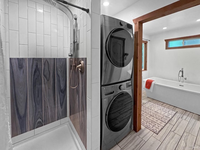 clothes washing area with stacked washing maching and dryer, laundry area, and recessed lighting