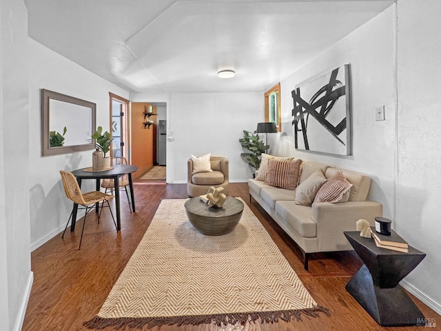 living area with dark wood-type flooring and baseboards