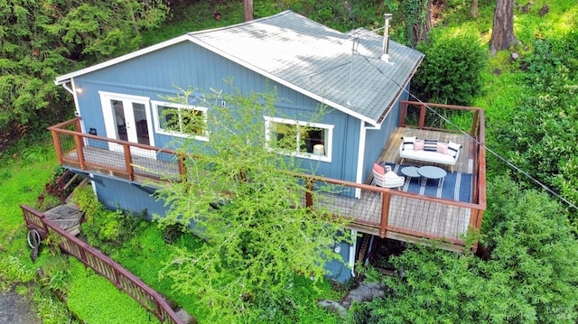 view of side of home with a wooden deck and french doors