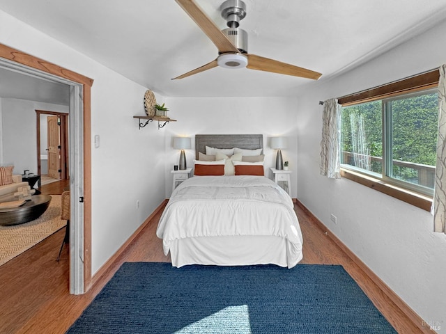 bedroom featuring baseboards, a ceiling fan, and wood finished floors