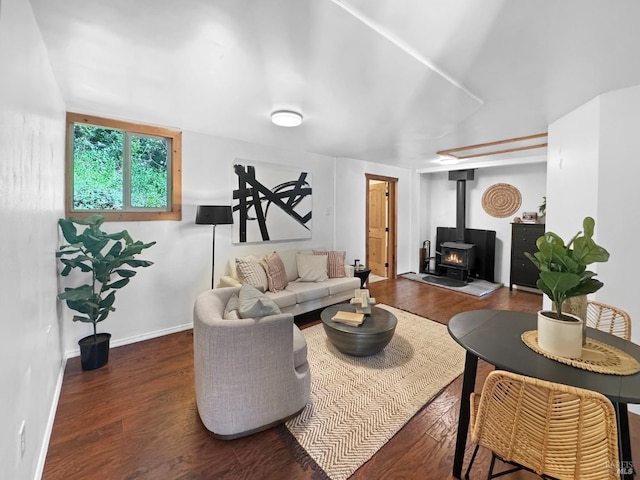 living room featuring baseboards, a wood stove, and wood finished floors