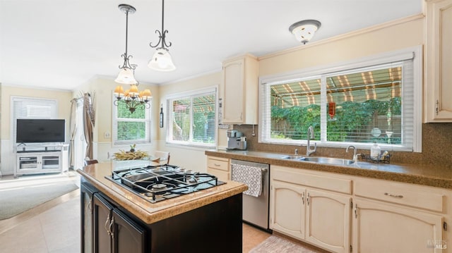 kitchen with cream cabinets, crown molding, appliances with stainless steel finishes, and a sink
