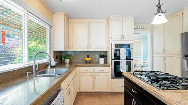 kitchen featuring light tile patterned flooring, cream cabinets, a sink, double oven, and black gas stovetop