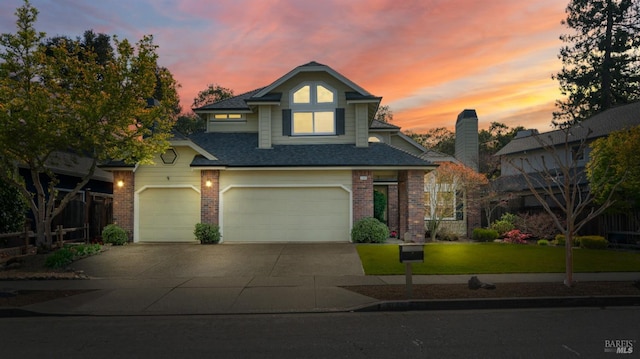 traditional-style house featuring concrete driveway, brick siding, roof with shingles, and a garage
