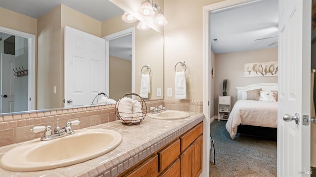 ensuite bathroom with a sink, double vanity, backsplash, and ensuite bathroom