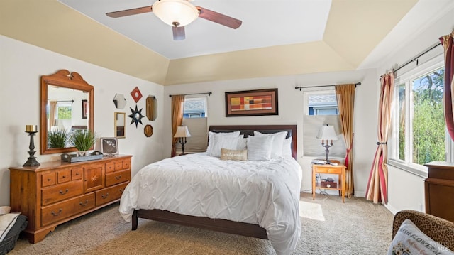 bedroom with vaulted ceiling, light colored carpet, and multiple windows
