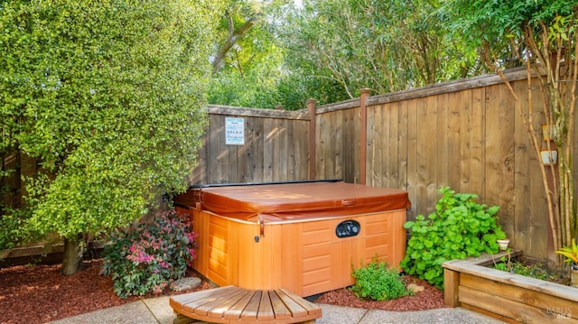 exterior space with a hot tub and fence