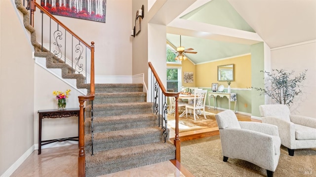 staircase featuring lofted ceiling, baseboards, crown molding, and ceiling fan