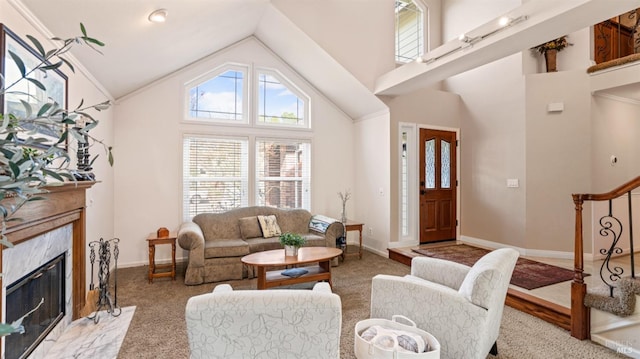 living area featuring a high end fireplace, high vaulted ceiling, and carpet floors