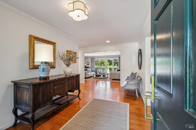 entryway with baseboards, crown molding, and wood finished floors