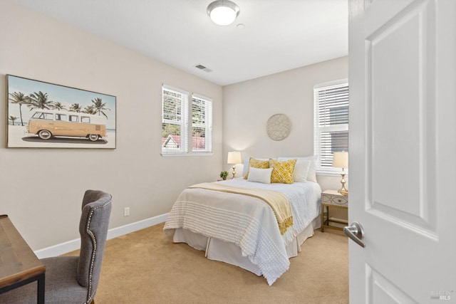 bedroom featuring baseboards, visible vents, and light colored carpet