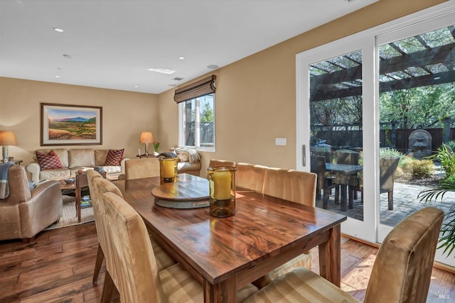 dining space with wood-type flooring and recessed lighting