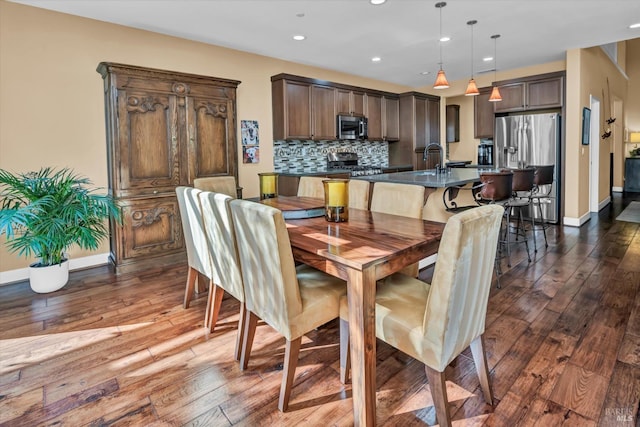 dining area featuring baseboards, recessed lighting, and dark wood finished floors