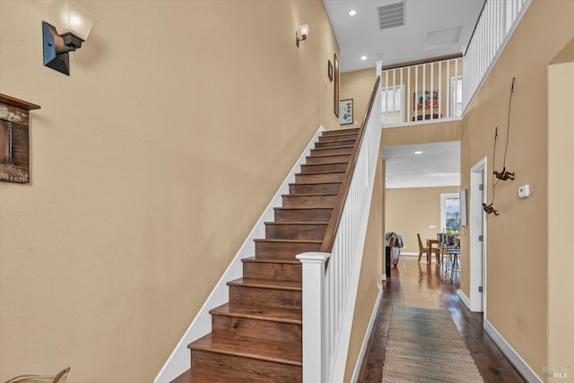 stairs with baseboards, visible vents, wood finished floors, and recessed lighting