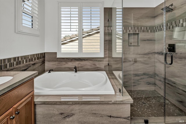 full bathroom with a marble finish shower, a garden tub, and vanity