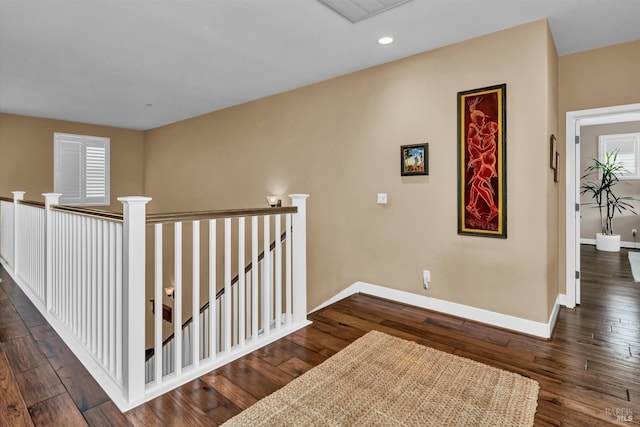 hall with an upstairs landing, visible vents, baseboards, recessed lighting, and dark wood finished floors