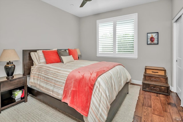 bedroom featuring baseboards, wood finished floors, and ceiling fan